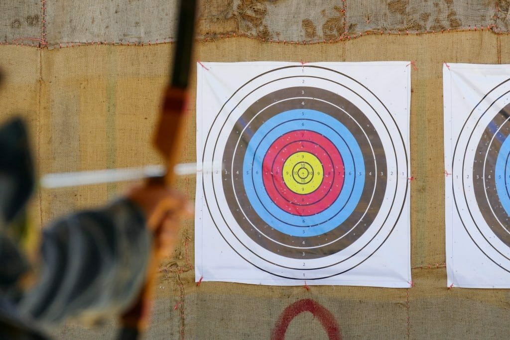 archer is aiming the arrow of the bow at the target