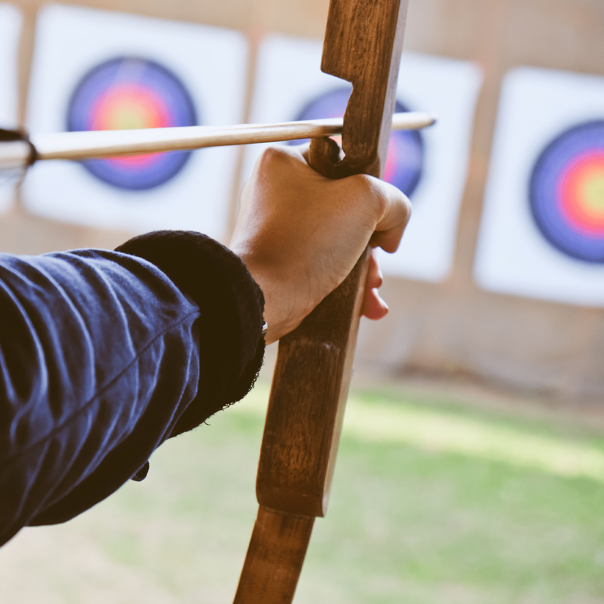 woman aiming bow and arrow at target